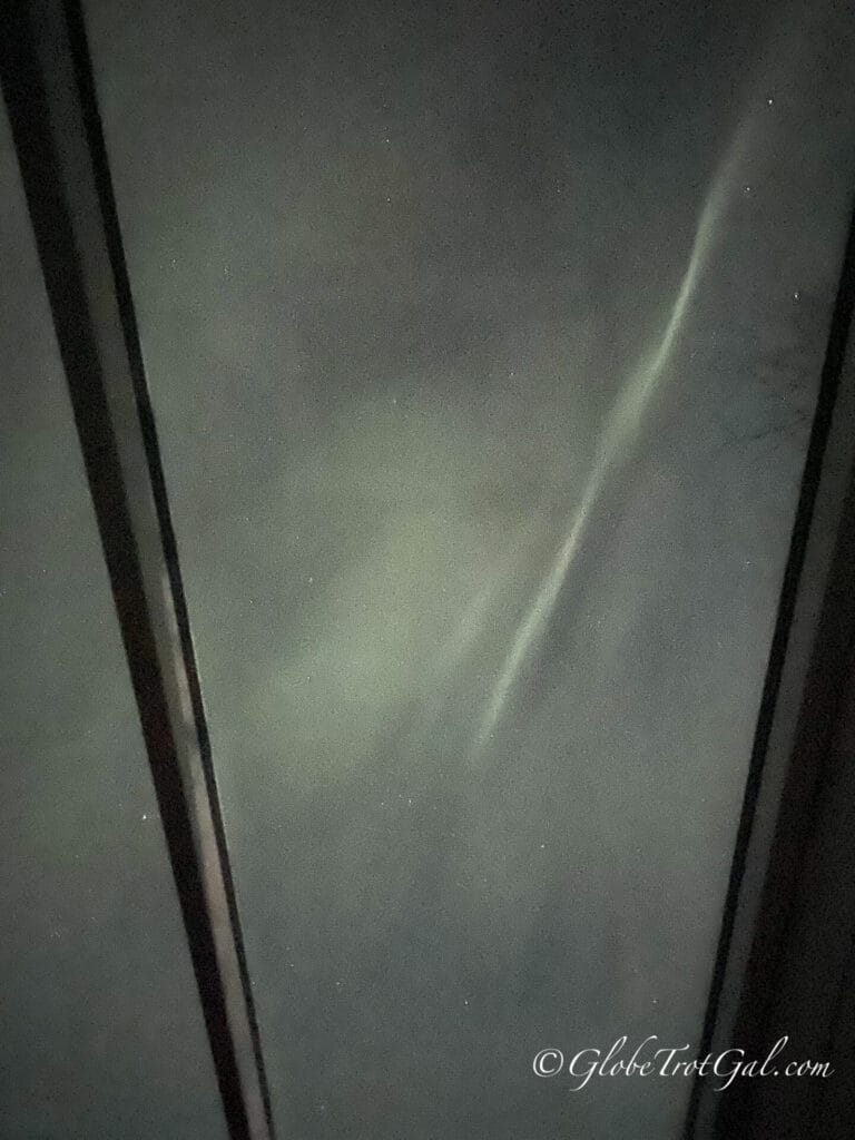 Northern lights seen through glass ceiling of cabin at Northern Lights Ranch near Levi Finland