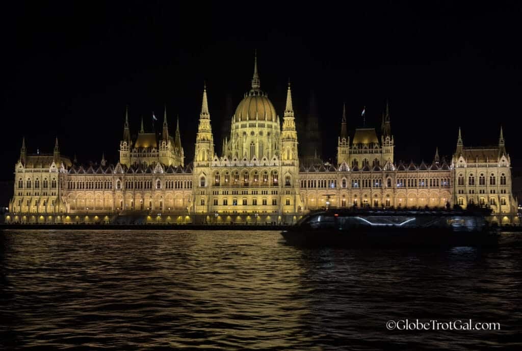 Hungarian Parliament Building illuminated at night with the lights reflecting in the Danube River in front of it in Budapest Hungary