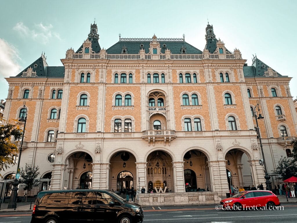 Exterior of the W Budapest in a grand peach and cream colored palace building in Budapest Hungary.