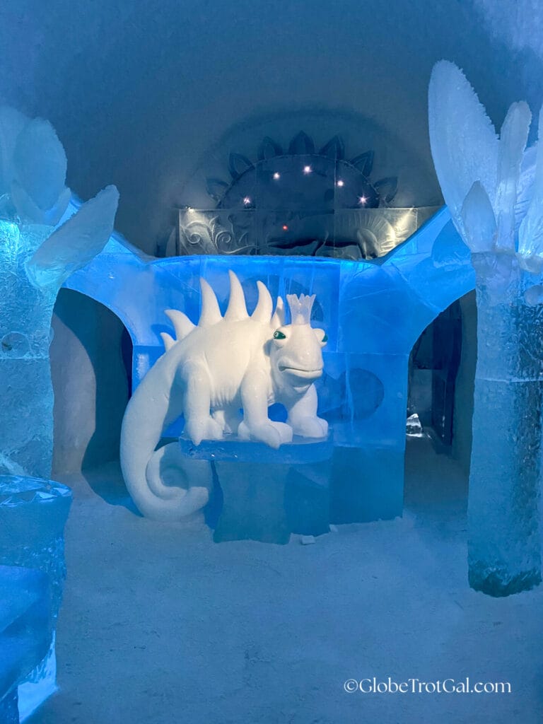 Ice sculpture of a large lizard wearing a crown in an art suite ice room at the Icehotel in Jukkasjärvi, Sweden