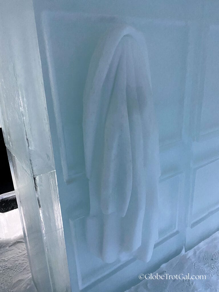 A wall made of ice with a hanging towel on it carved out of ice at the Icehotel in Jukkasjärvi, Sweden