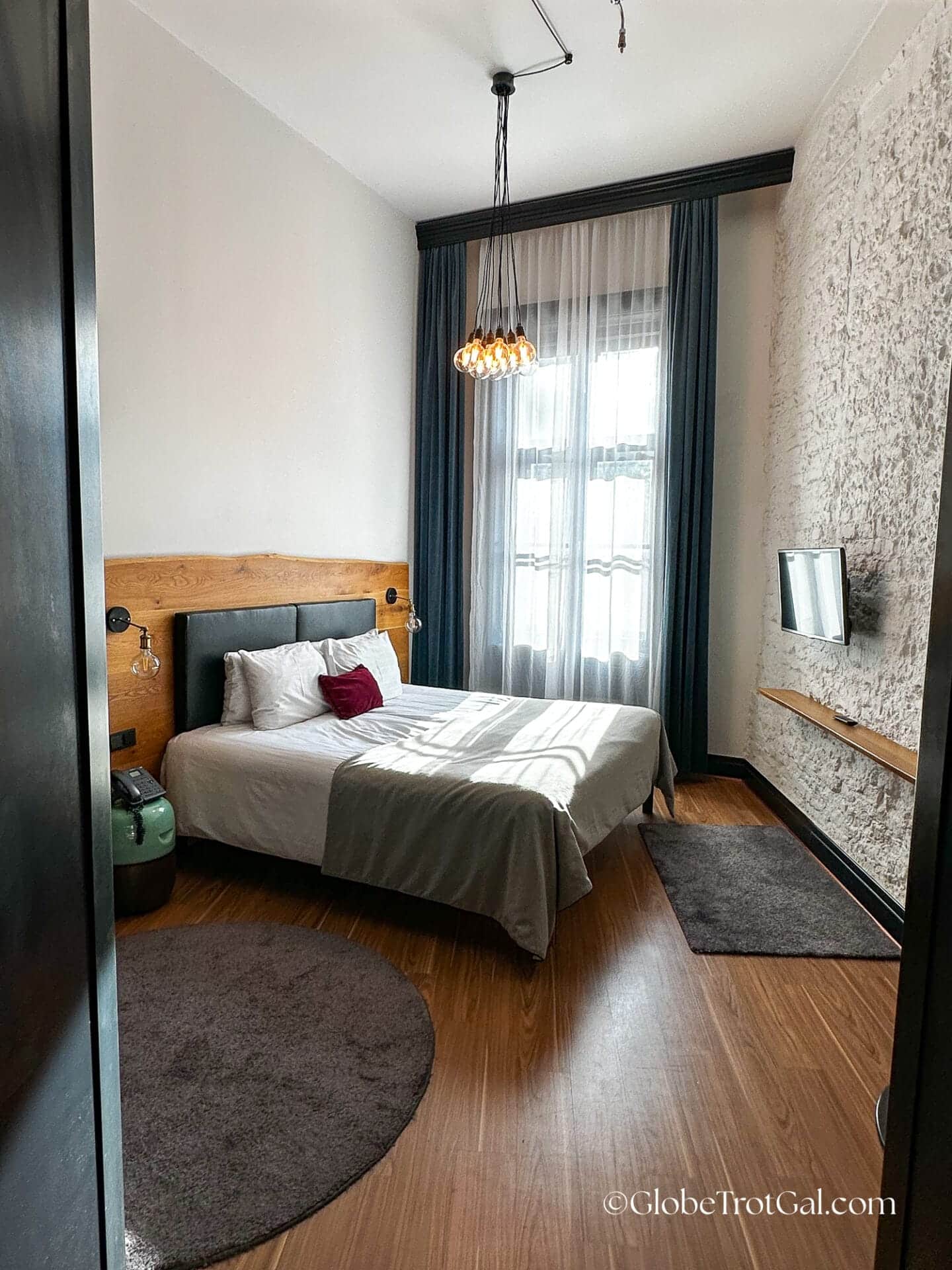 Large hotel room with bed, large window, and high ceilings at the Hotel Rum in Budapest Hungary