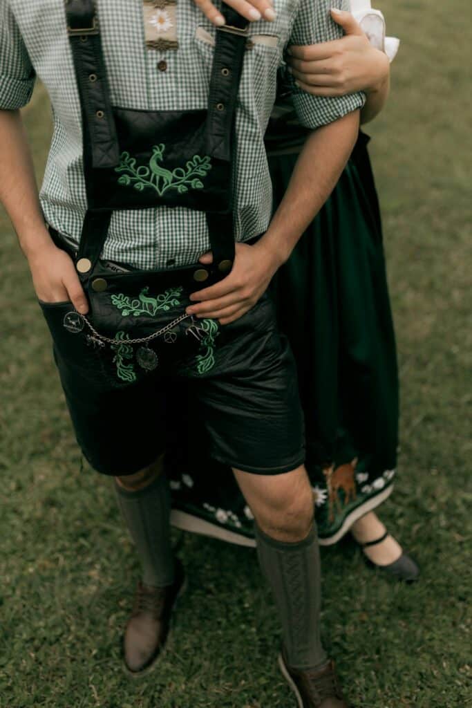 Close-up of a man in lederhosen and woman in dirndl, showcasing Bavarian fashion.