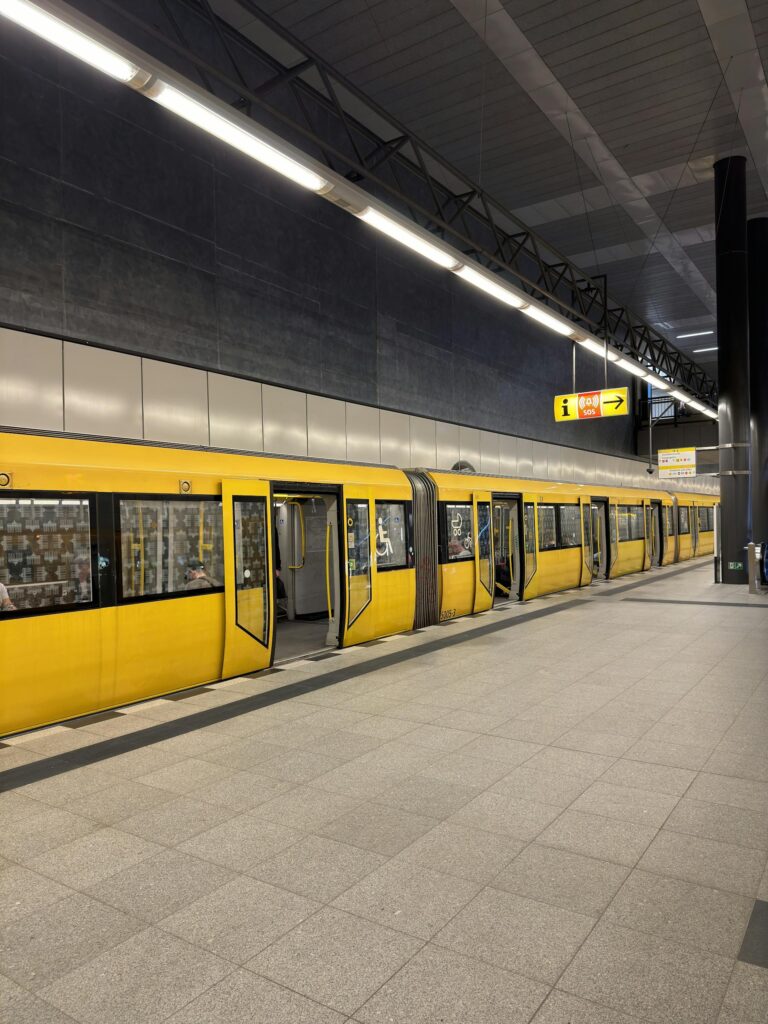 Yellow subway train at a modern Berlin station platform, showcasing public transportation in Germany.